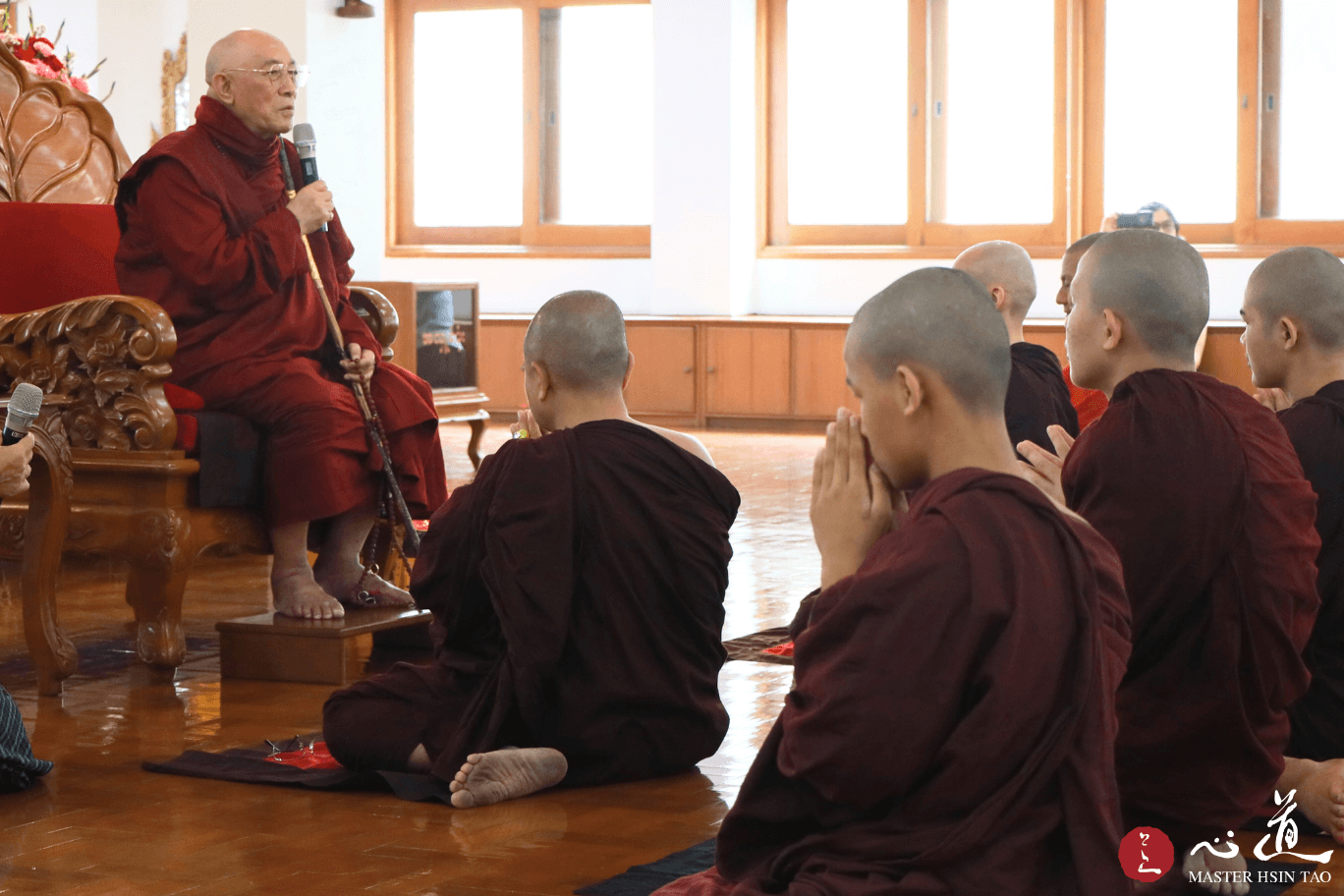 灵鹫山心道法师于缅甸禅修中心为僧众开示，前方多位僧众合掌恭敬聆听